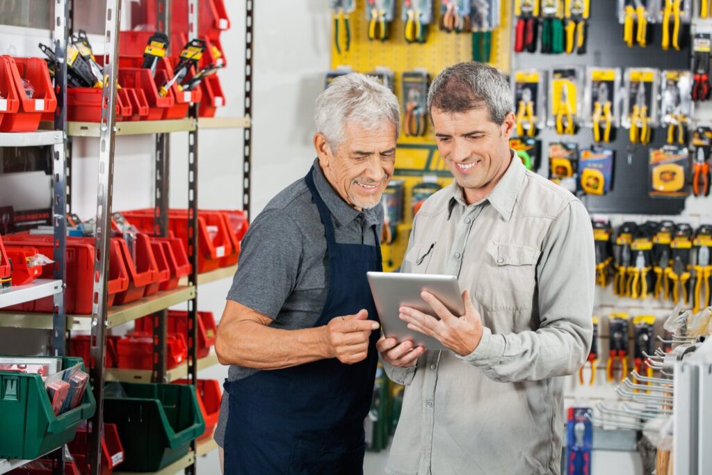 small businesses two men holding tablet in hardware retail store