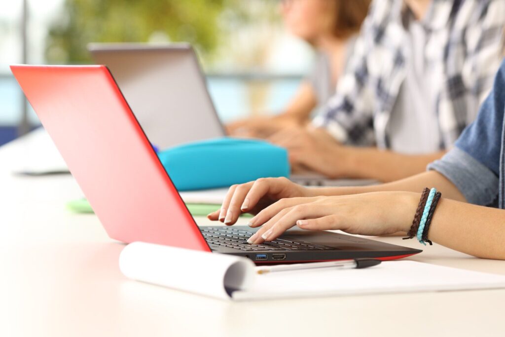 people typing on their laptops on desk