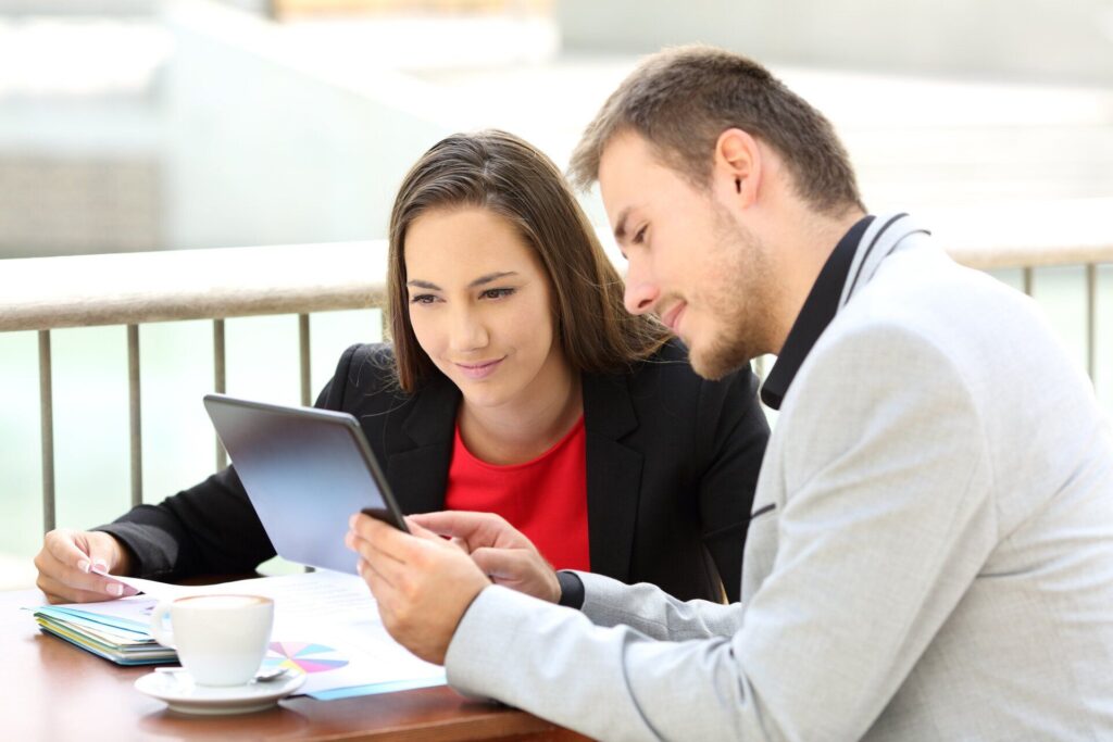 coworkers showing info on tablet to each other