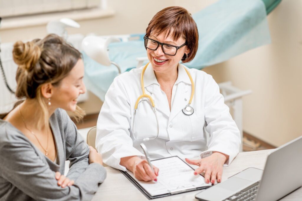 smiling female doctor talking with patient writing on a notepad